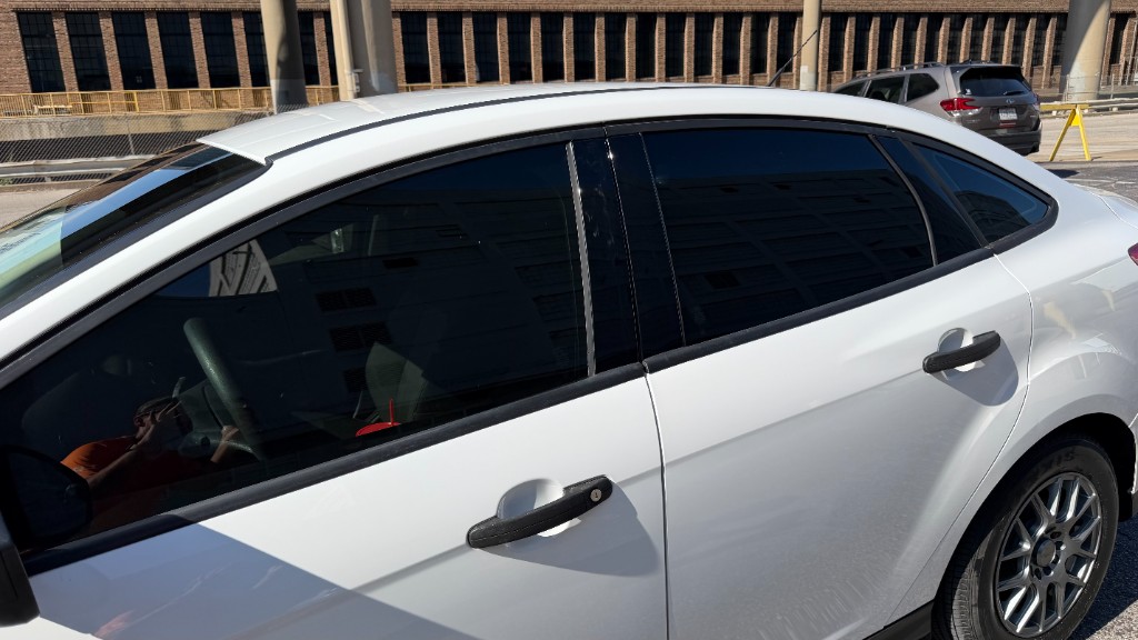 Close-up of white sedan windows showing seamless 35% and 5% window tint installation