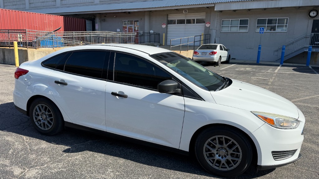 White Ford Focus front quarter view under direct daylight showing 35% front tint